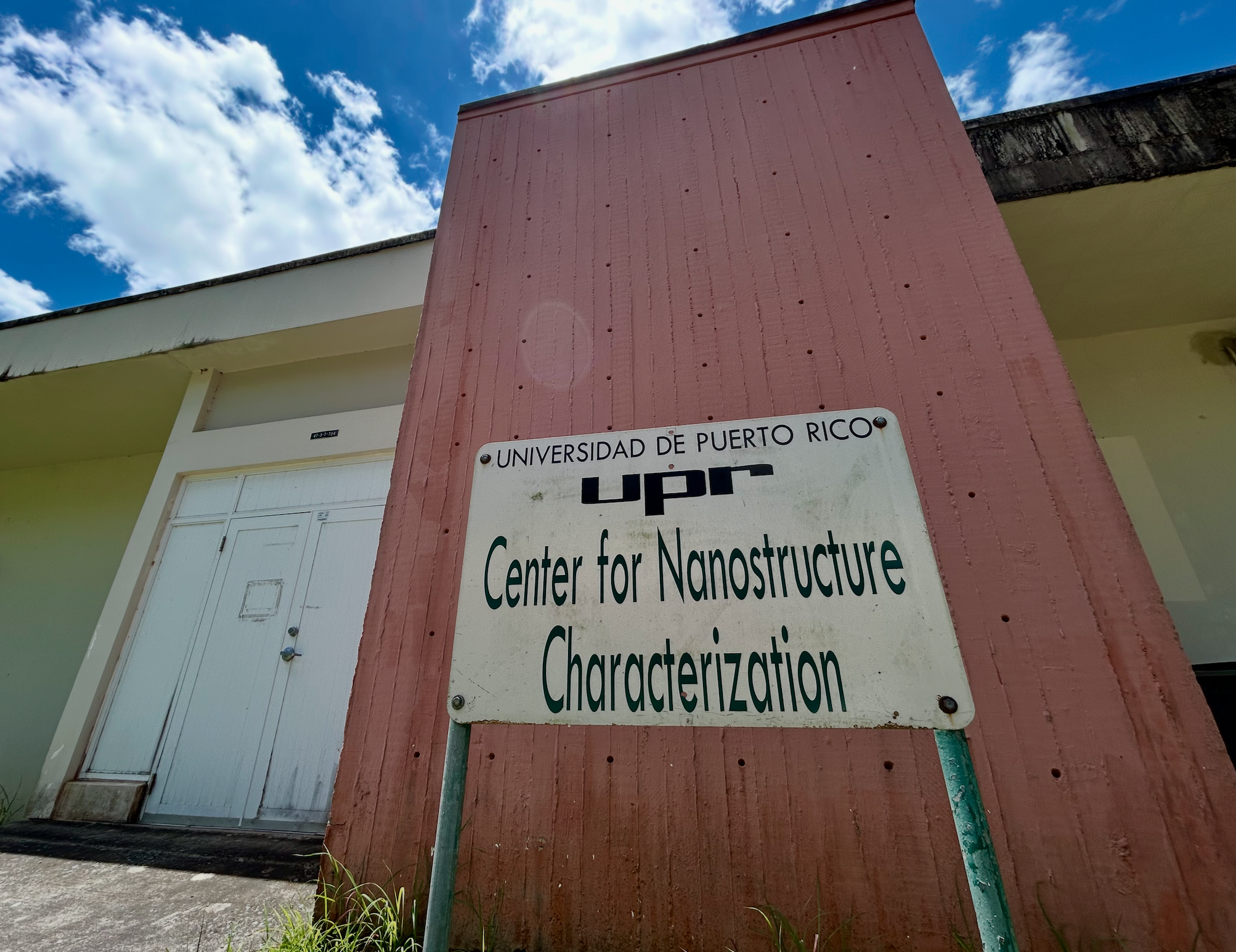 a picture of the front entrance of the CeNaC building with a sign that reads UPR Center for Nanostructure Characterization
